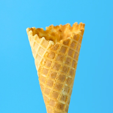 A waffle cone with no ice cream in a with a blue background