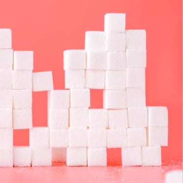 A pile of several sugar cubes with a red background